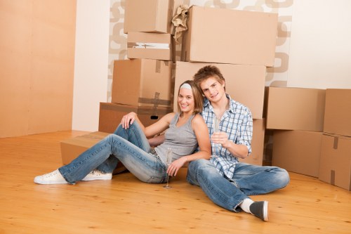 Removalists carrying furniture through a narrow Soho building staircase