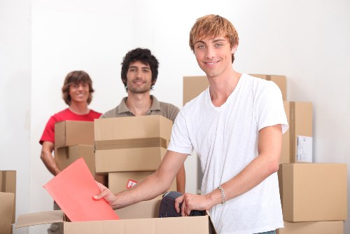 Professional movers carrying boxes through a narrow hallway